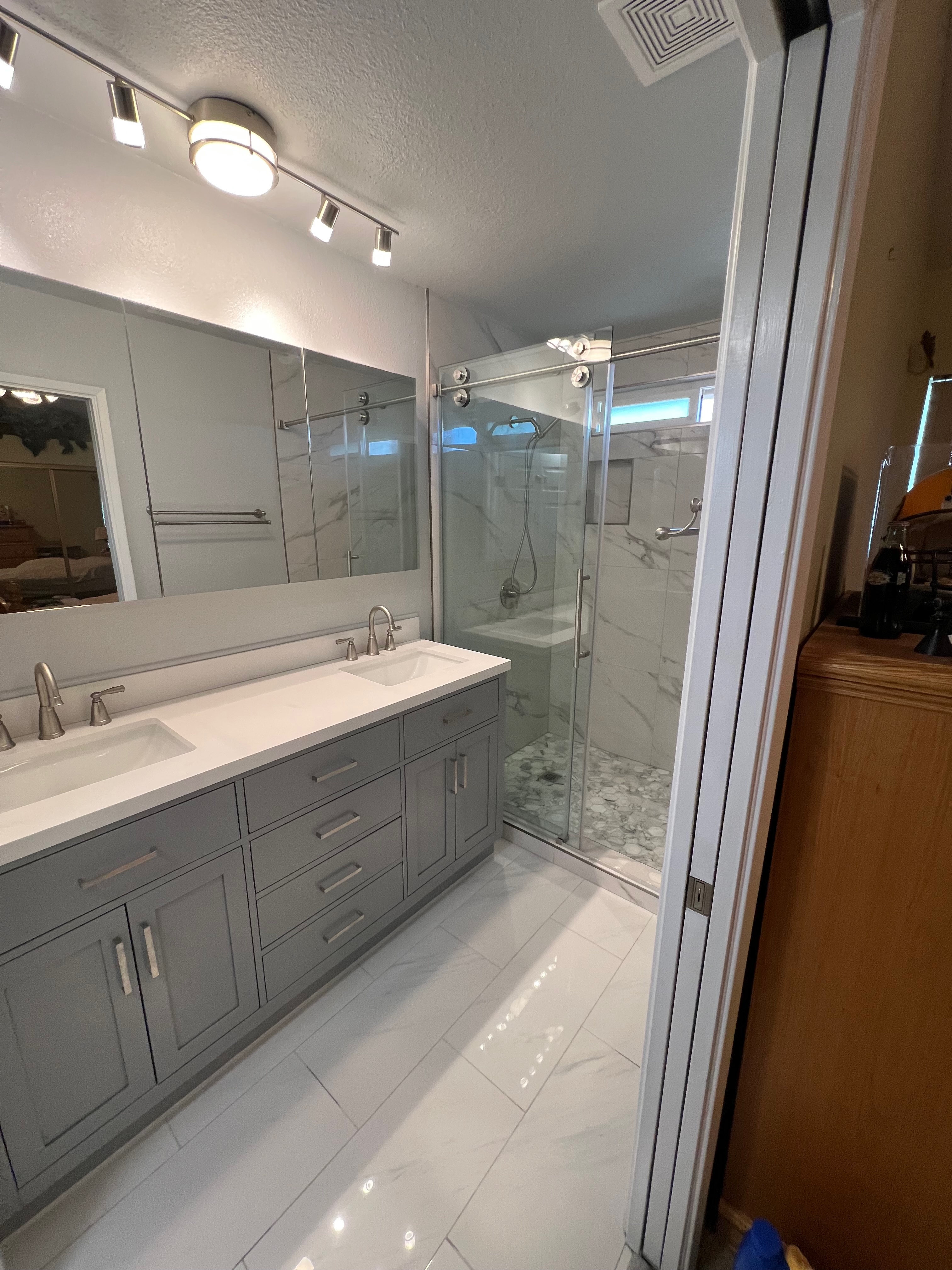 After photo of walk-in shower conversion with frameless glass doors and marble tile Riverside CA