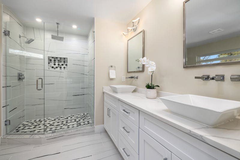 Luxury walk-in shower with marble tile and white vanity bathroom remodel Riverside CA