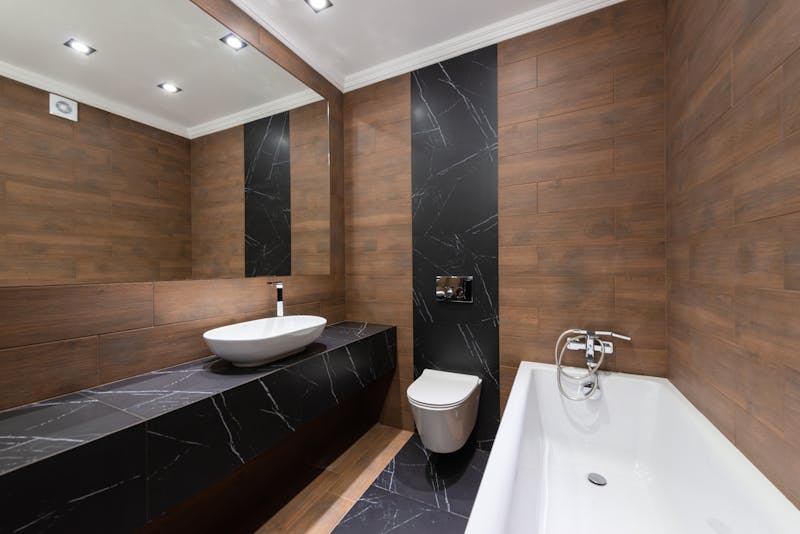 Luxury dark marble and wood bathroom with soaking tub Riverside California